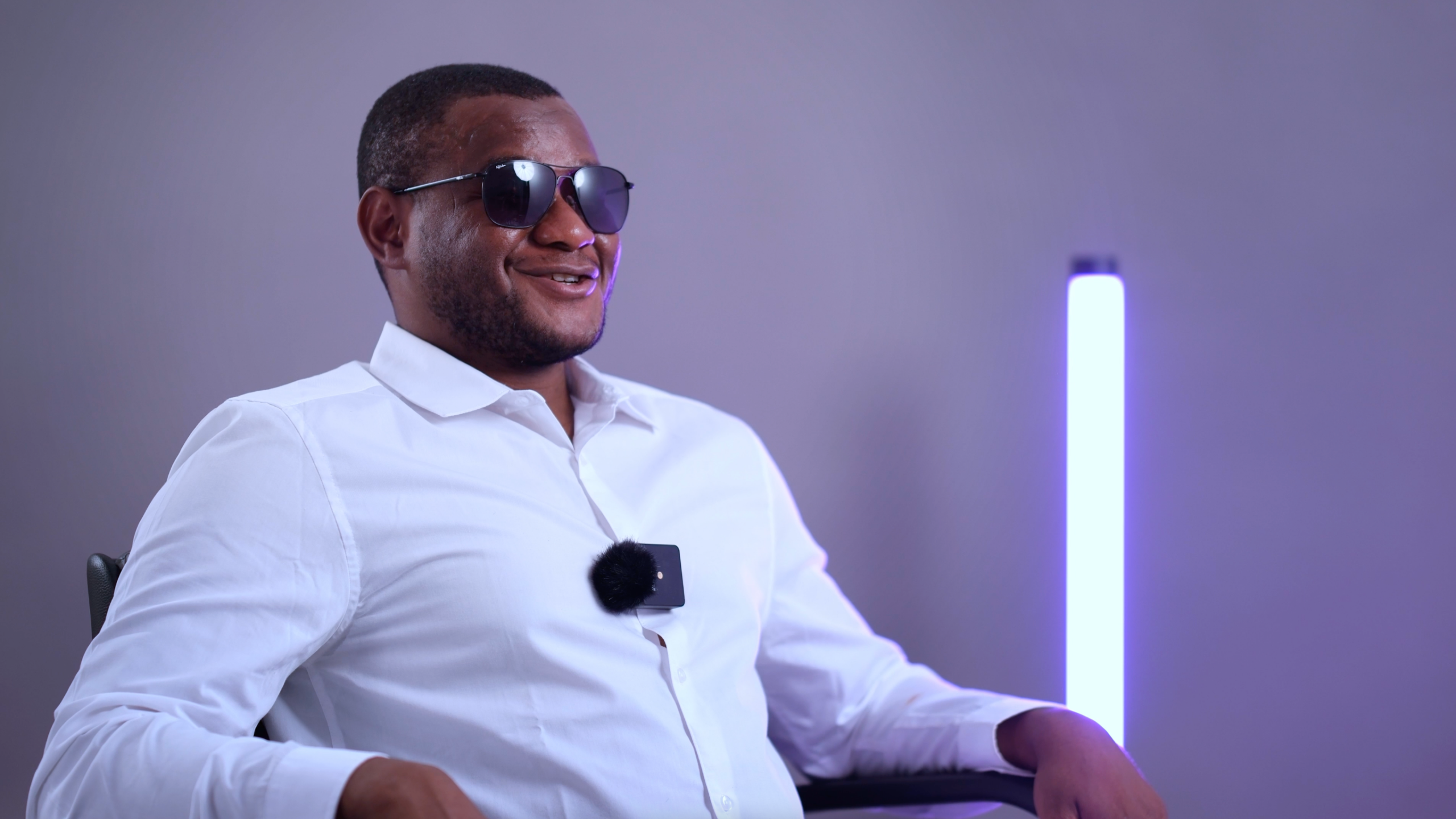 Sadam sourit avec ses lunettes de soleil devant la caméra